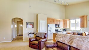 A spacious living room with a leather sofa and a dining area with wooden cabinets and a refrigerator. - Park City Area Lodge: 9 Mi to Timber Lakes (Heber City)