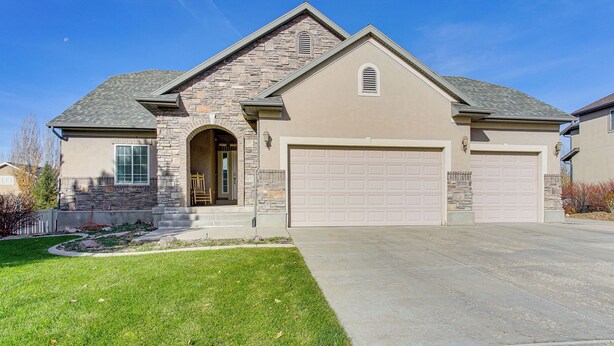 A two-story house with a stone facade, a garage, and a well-maintained lawn. - Park City Area Lodge: 9 Mi to Timber Lakes (Heber City)