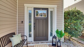A front porch with a bench, a doormat, and a potted plant. - Golf, Shop + Relax: Family Bluffton Home (Bluffton)