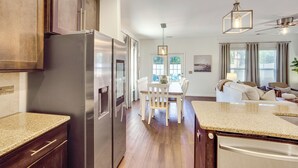 A modern kitchen with a built-in refrigerator, wooden cabinets, and a granite countertop. - Golf, Shop + Relax: Family Bluffton Home (Bluffton)