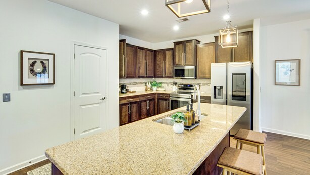 A modern kitchen with granite countertops, stainless steel appliances, and wooden cabinets. - Golf, Shop + Relax: Family Bluffton Home (Bluffton)