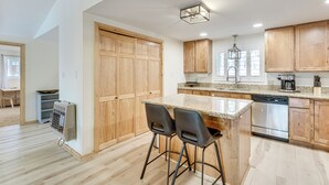 Eine moderne Küche mit Holzschränken, einer Granit Arbeitsplatte und Edelstahlgeräten.