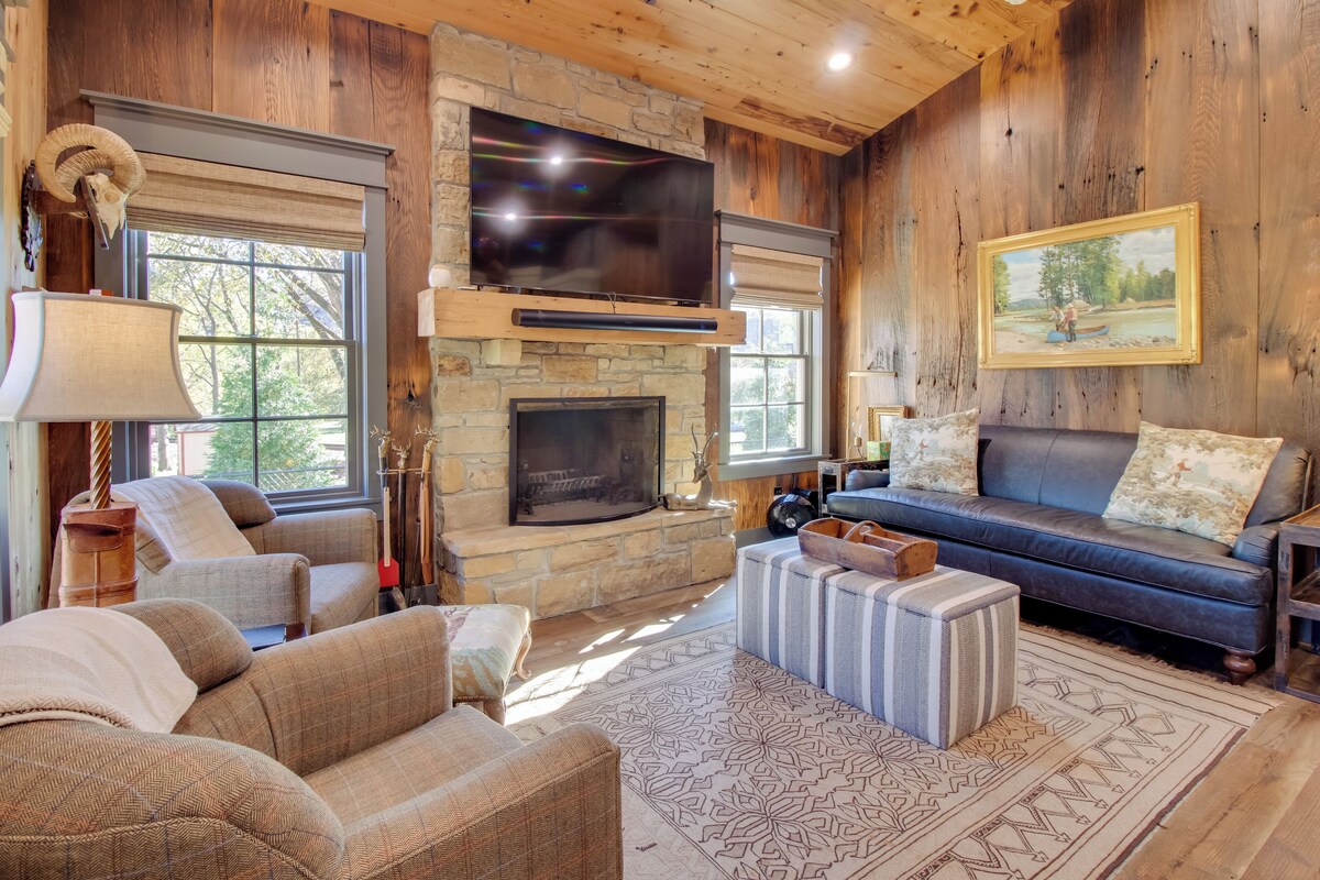 A cozy living room with a stone fireplace, a flat-screen TV, and comfortable seating.