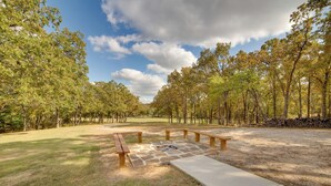 Een park met picknicktafels en een vuurkuil.