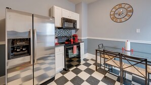 A kitchen with a refrigerator, microwave, oven, and coffee maker. There is a clock on the wall and a checkered floor. - Walkable Racine Retreat! 1 Mi to Lake Michigan (Racine)