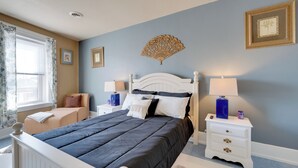 A bedroom with a bed, nightstands, a window with curtains, and wall decorations. - Walkable Racine Retreat! 1 Mi to Lake Michigan (Racine)
