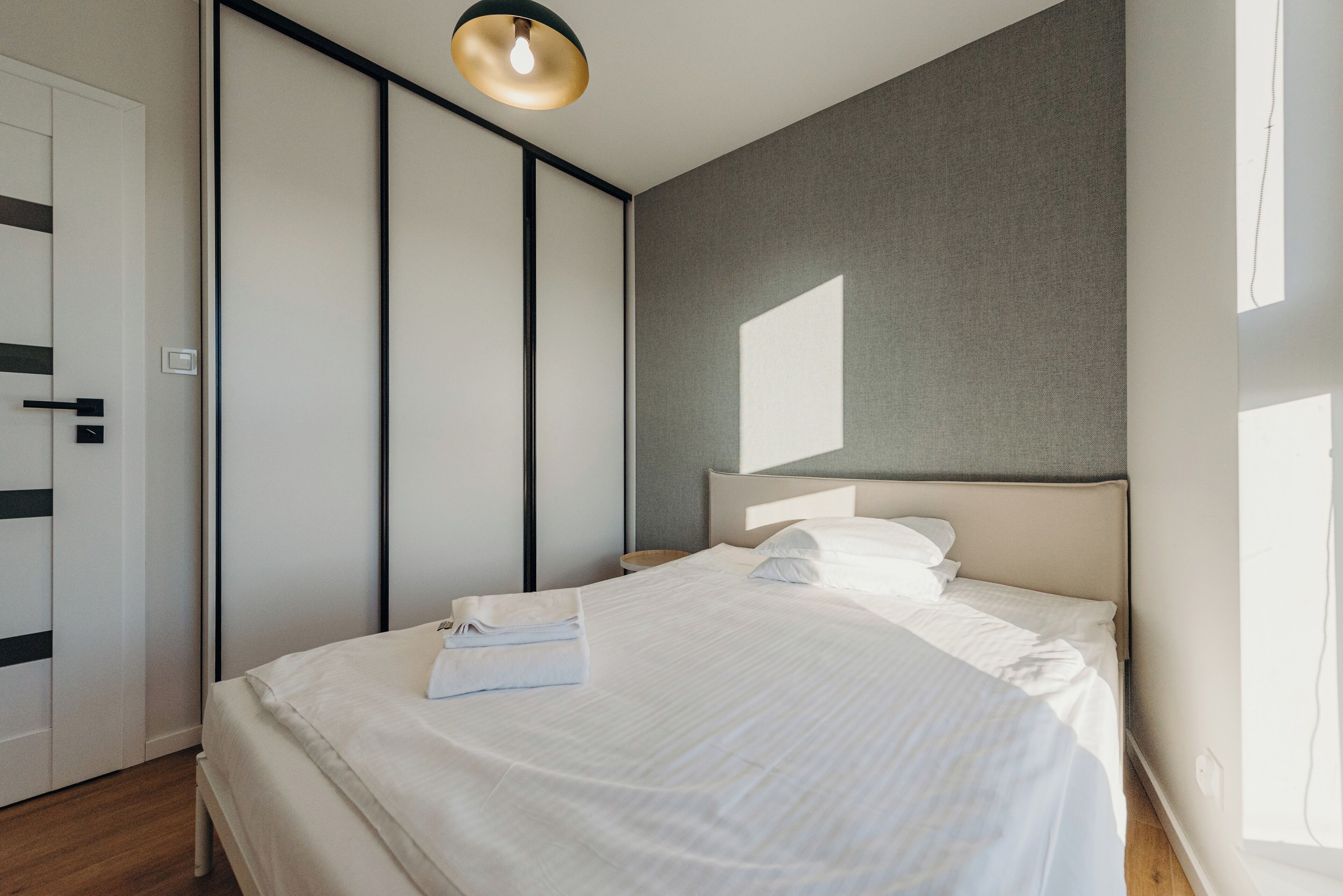 Une chambre à coucher moderne avec un lit, des tables de chevet et une armoire.