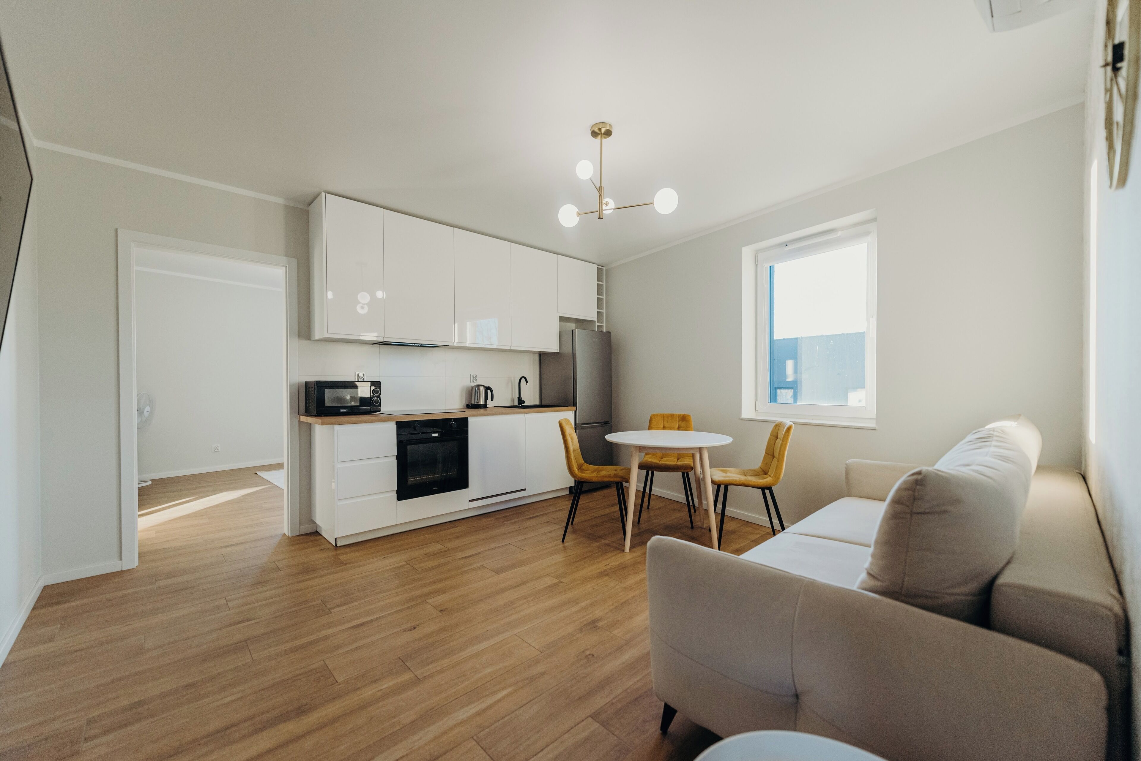 Un appartement moderne comprenant une cuisine, un coin repas et un salon.