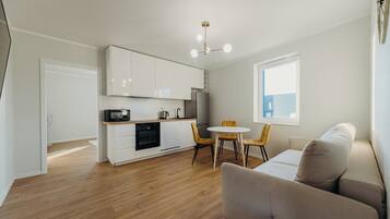 Un appartement moderne comprenant une cuisine, un coin repas et un salon.