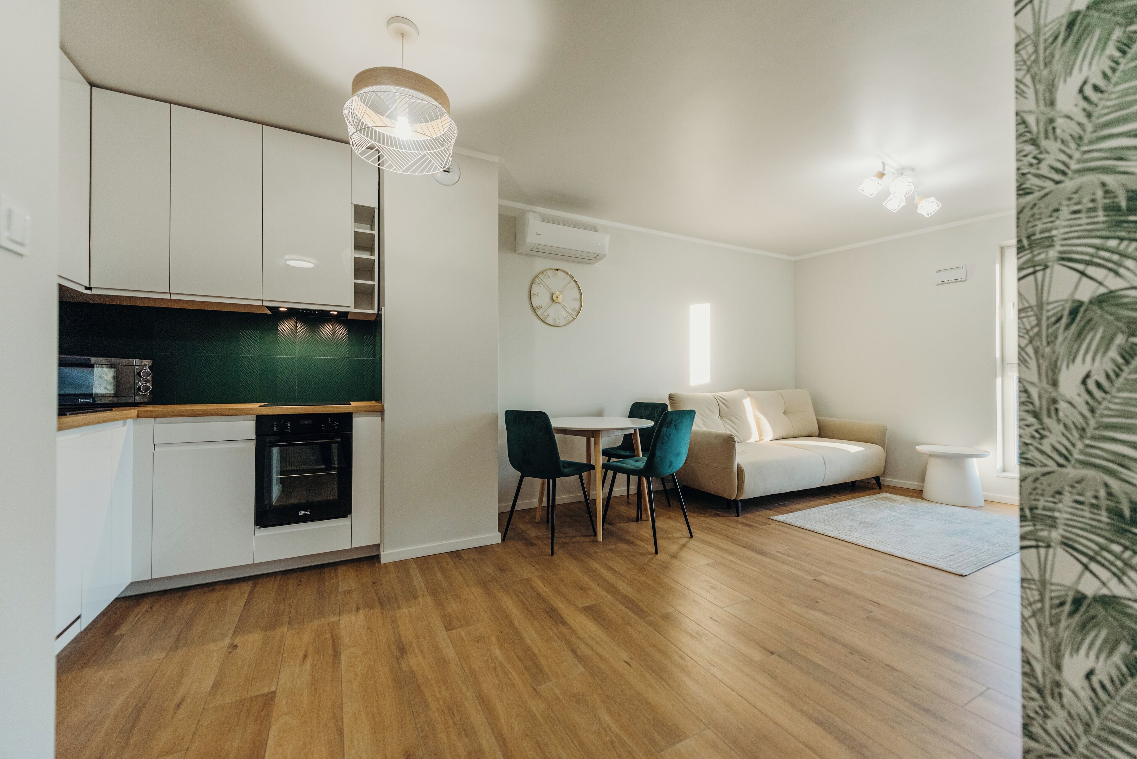 Un espacio habitable compacto con kitchenette, comedor y sofá.