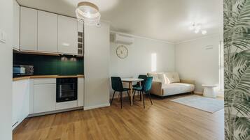 Un espacio habitable compacto con kitchenette, comedor y sofá.