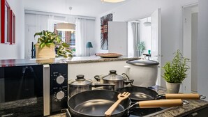 Eine moderne Küche mit Gasherd, Töpfen, Pfannen und einem Holzspatel.