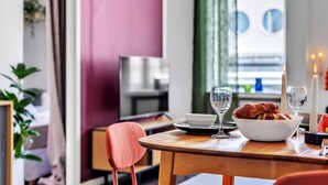 Comedor con mesa dispuesta para dos personas, mostrando un plato de comida, dos copas de vino y velas.