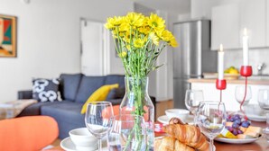 Een ontbijtruimte met een gedekte tafel, onder andere met croissants, fruit en wijnglazen.