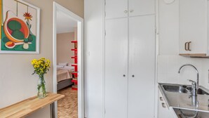 A compact kitchen with a sink, cabinets, and a wooden floor. - Vibrant & Central w Netflix, WiFi, 200m tram/bus (Helsinki)