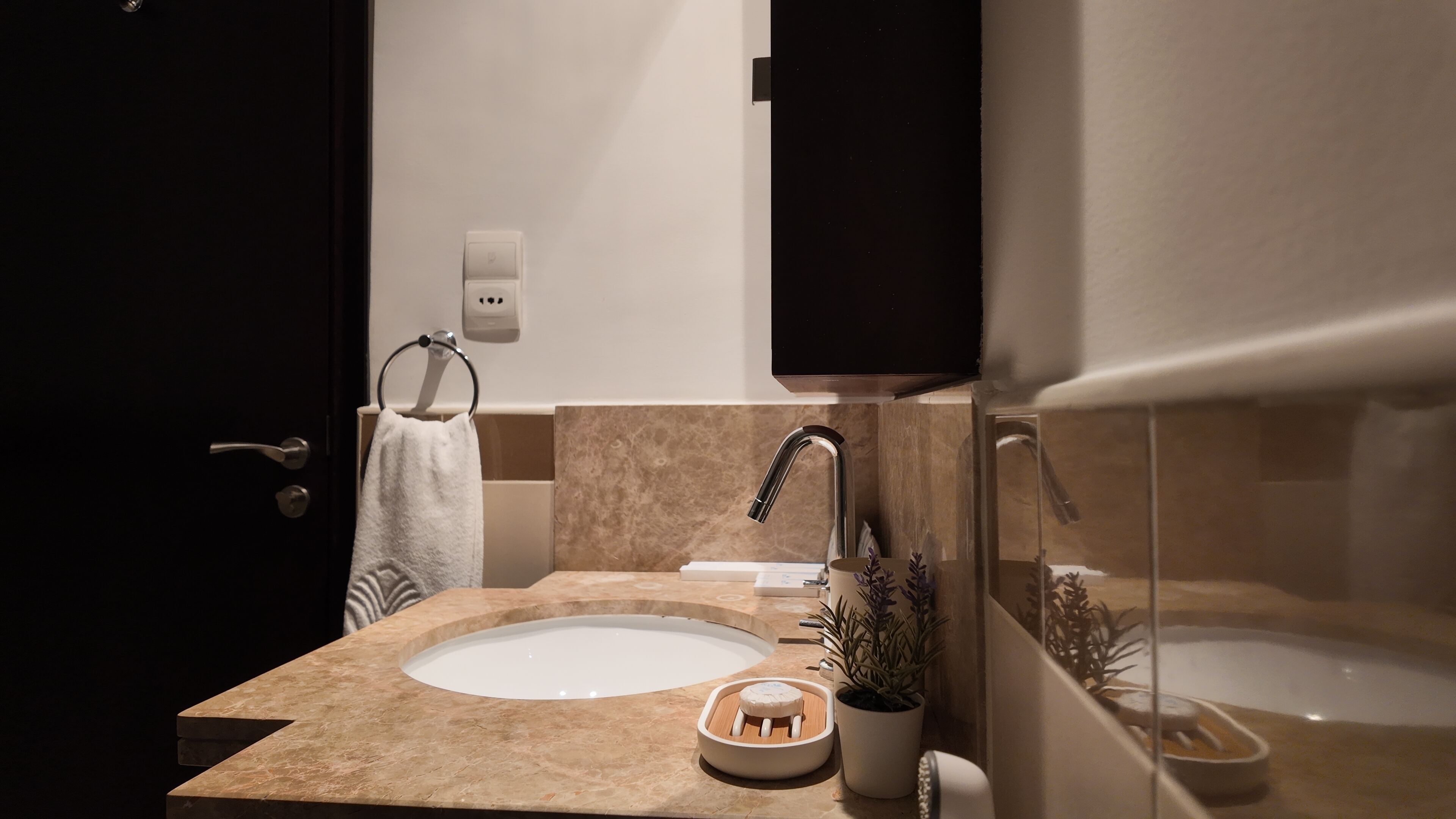 Un baño moderno con lavamanos, espejo y bañera.