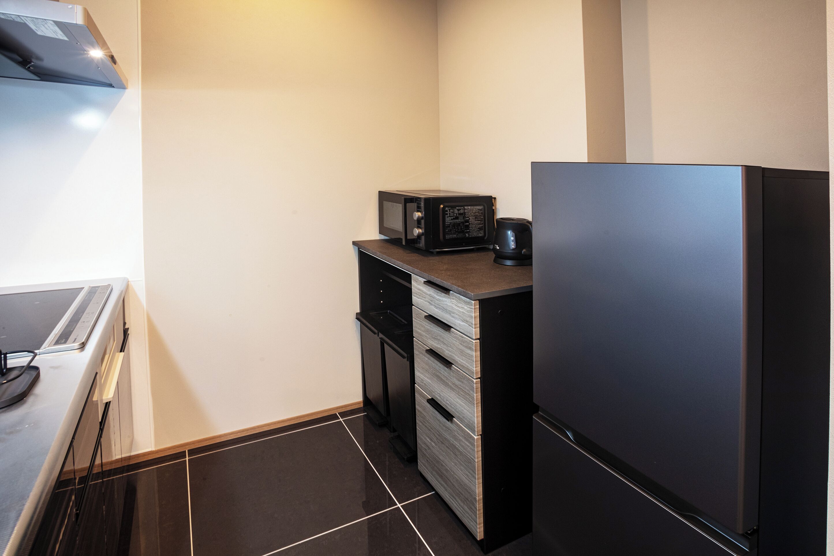A compact kitchen with a microwave, coffee maker, and a refrigerator.