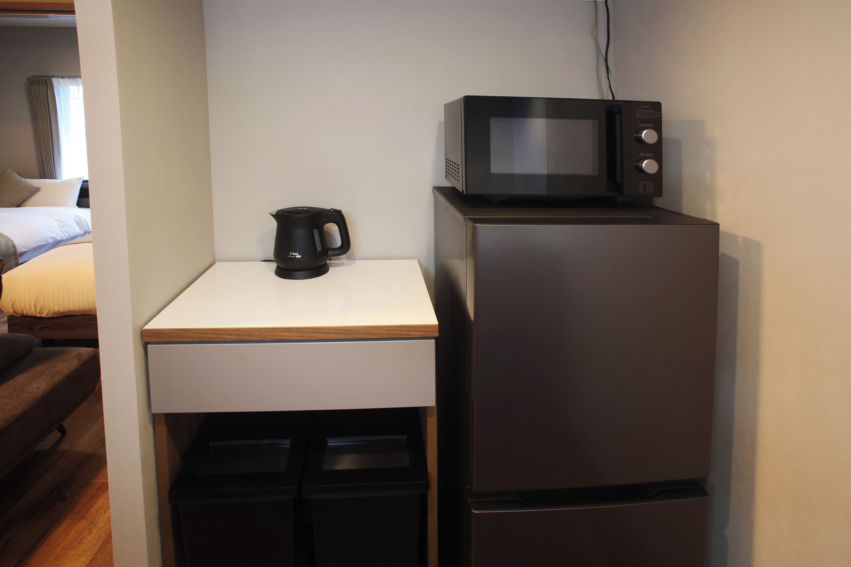 A compact kitchenette with a microwave, a coffee maker, and a refrigerator.