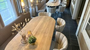 Zona pranzo con un grande tavolo ovale, diverse sedie e lampade a sospensione.