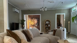 Un soggiorno moderno con un divano componibile, un televisore a schermo piatto, un tavolino in legno e un elemento decorativo a parete.
