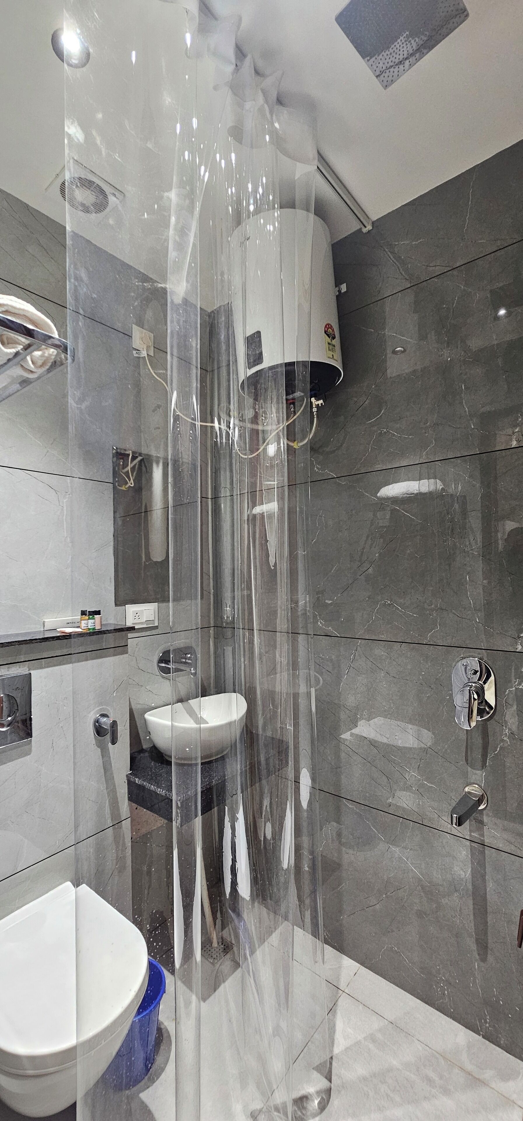 A modern bathroom with a glass-enclosed shower, a white sink, and a toilet.