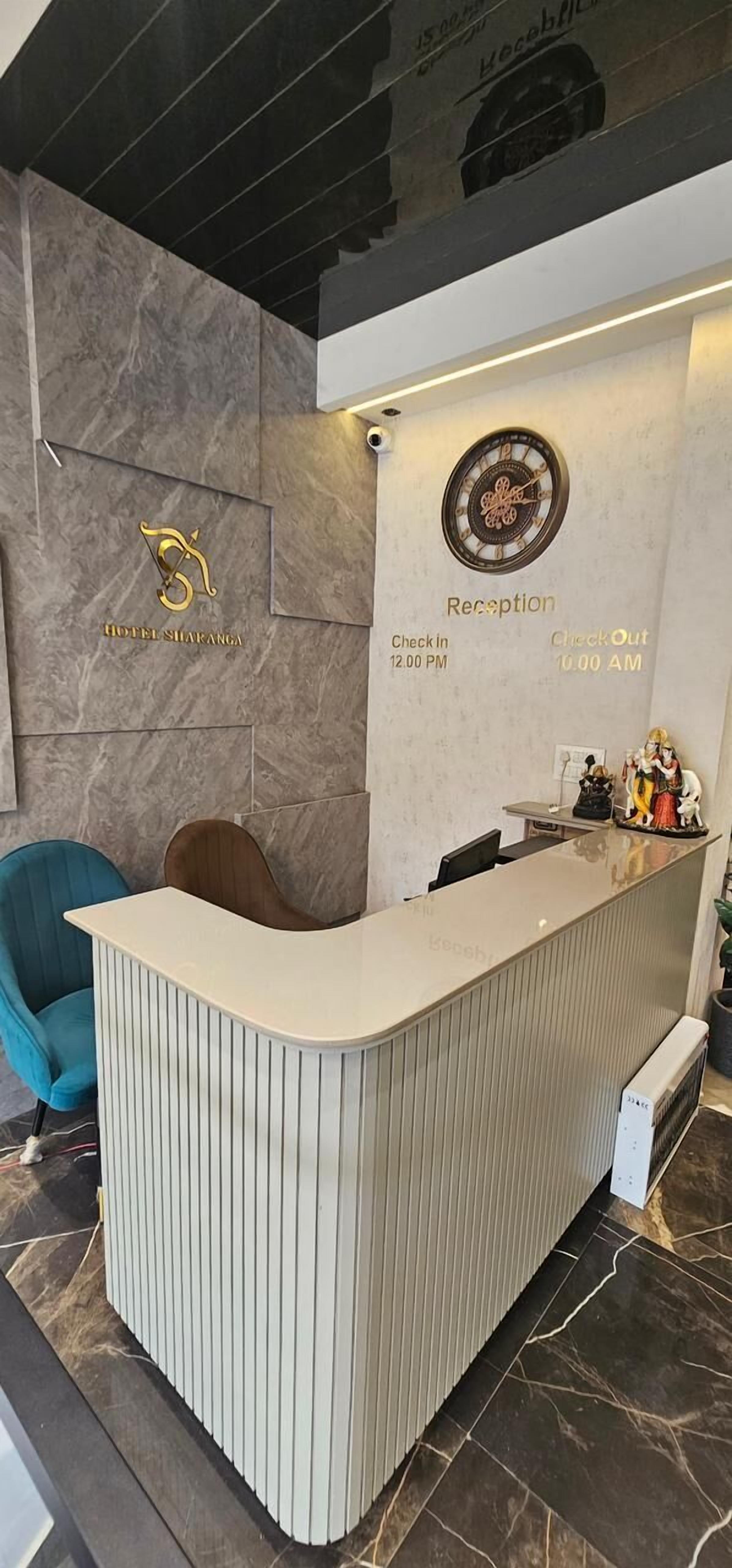 Un mostrador de recepción de hotel con un reloj, un letrero de recepción y un logotipo.