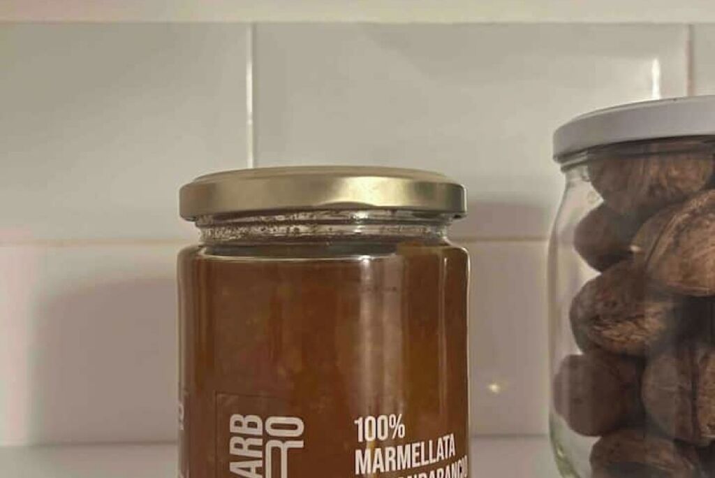 Un pot de confiture de marmelade à 100 % à côté d’un bocal de fruits secs.