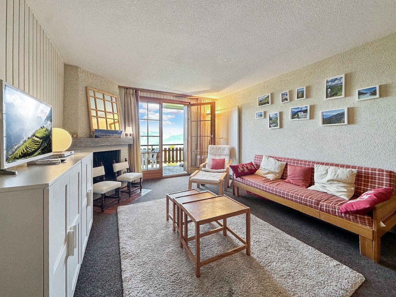 A cozy living area with a sofa, a coffee table, a TV, and a dining table.