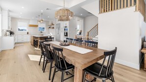 Una cucina moderna con isola centrale, tavolo da pranzo in legno e sedie nere.