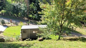 A small, single-story mobile home with a flat roof, surrounded by a grassy yard and trees. - Watts River Tiny - Hidden, but Close to Township (Healesville)