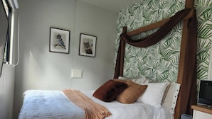 A neatly made bed with a white duvet, brown pillows, and a brown throw blanket. There are two framed pictures on the wall above the bed. - Watts River Tiny - Hidden, but Close to Township (Healesville)