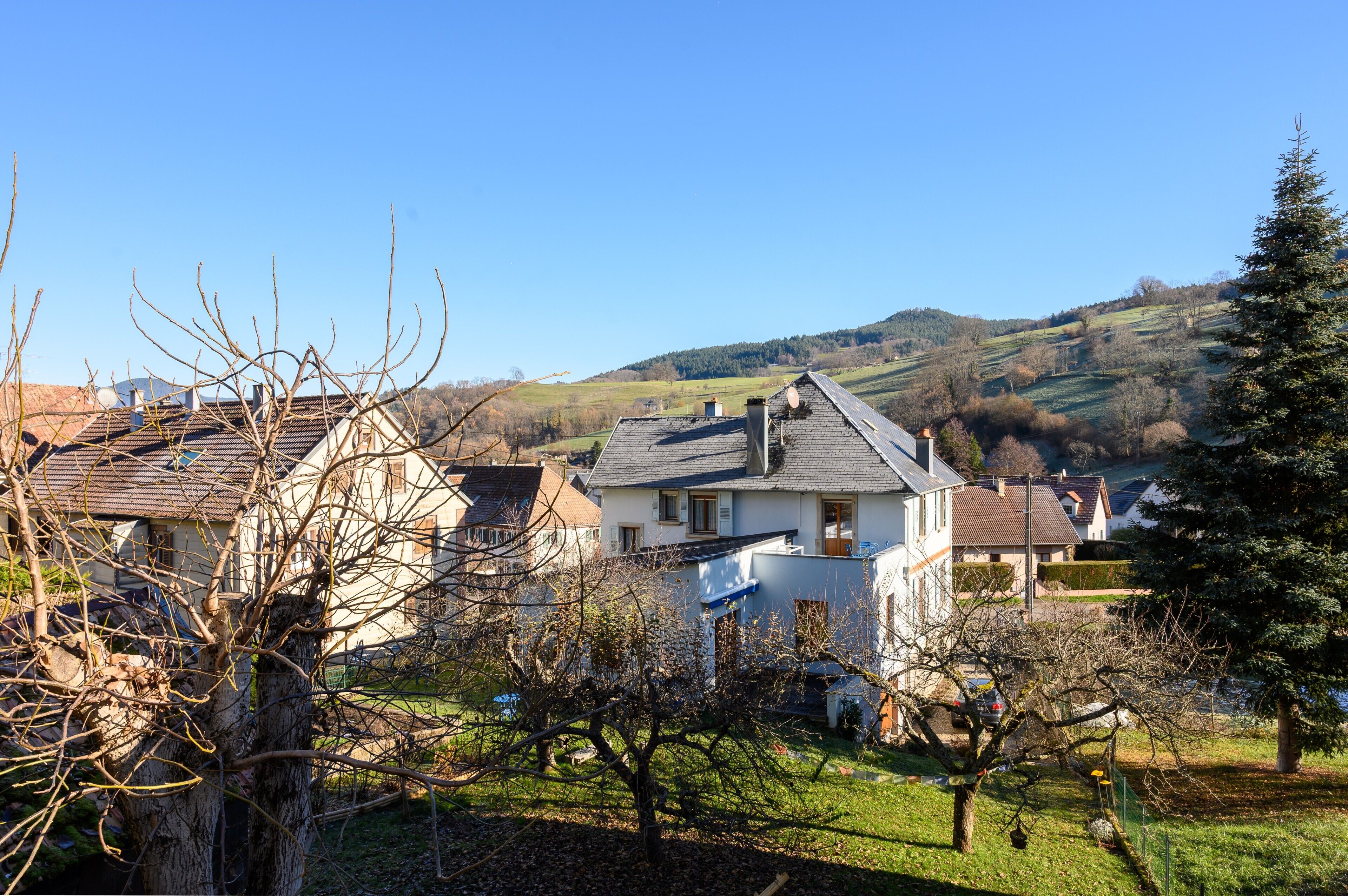 Un área residencial con casas, cielo despejado y un paisaje montañoso al fondo.