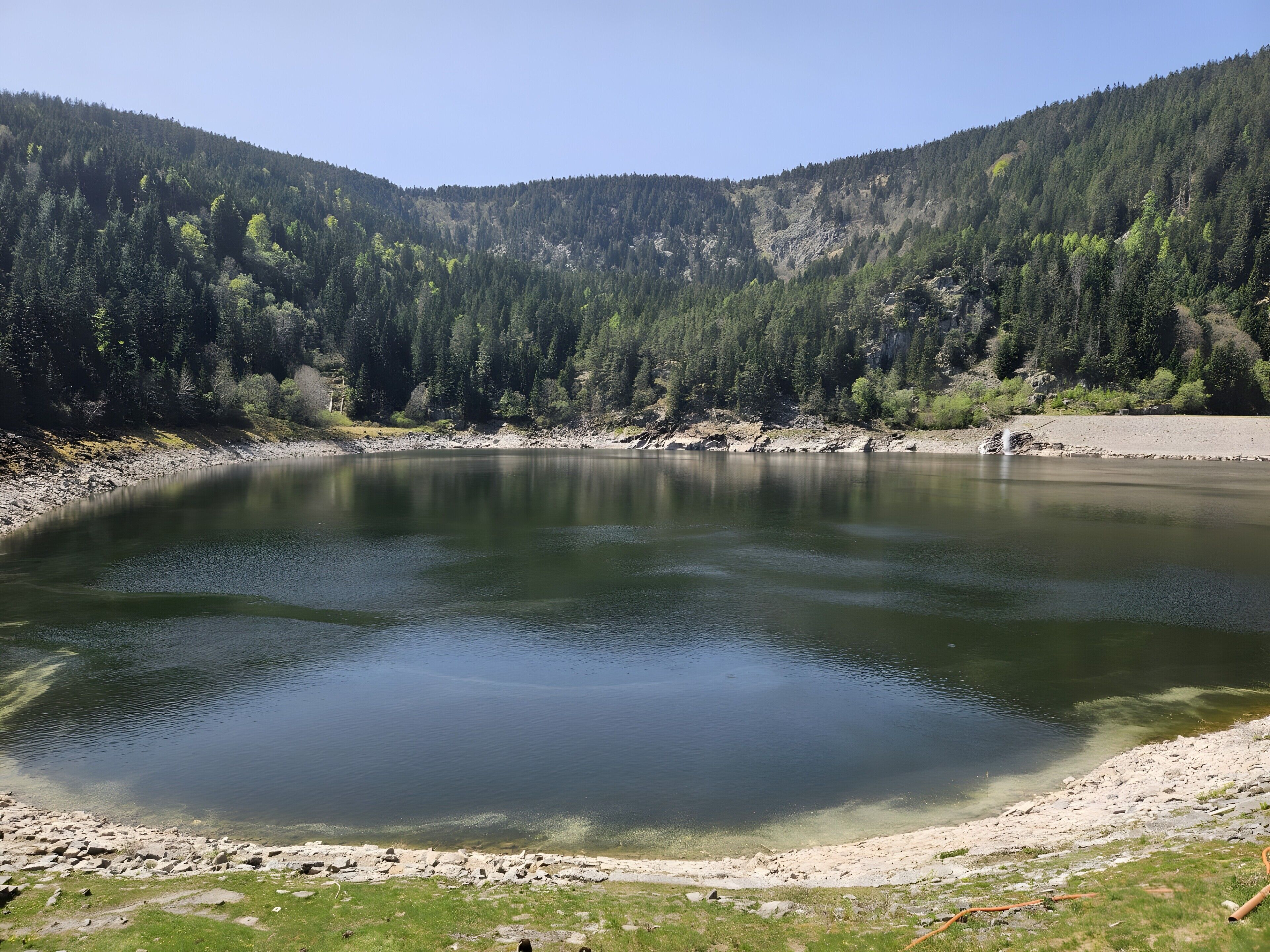 Un llac envoltat de turons boscosos.