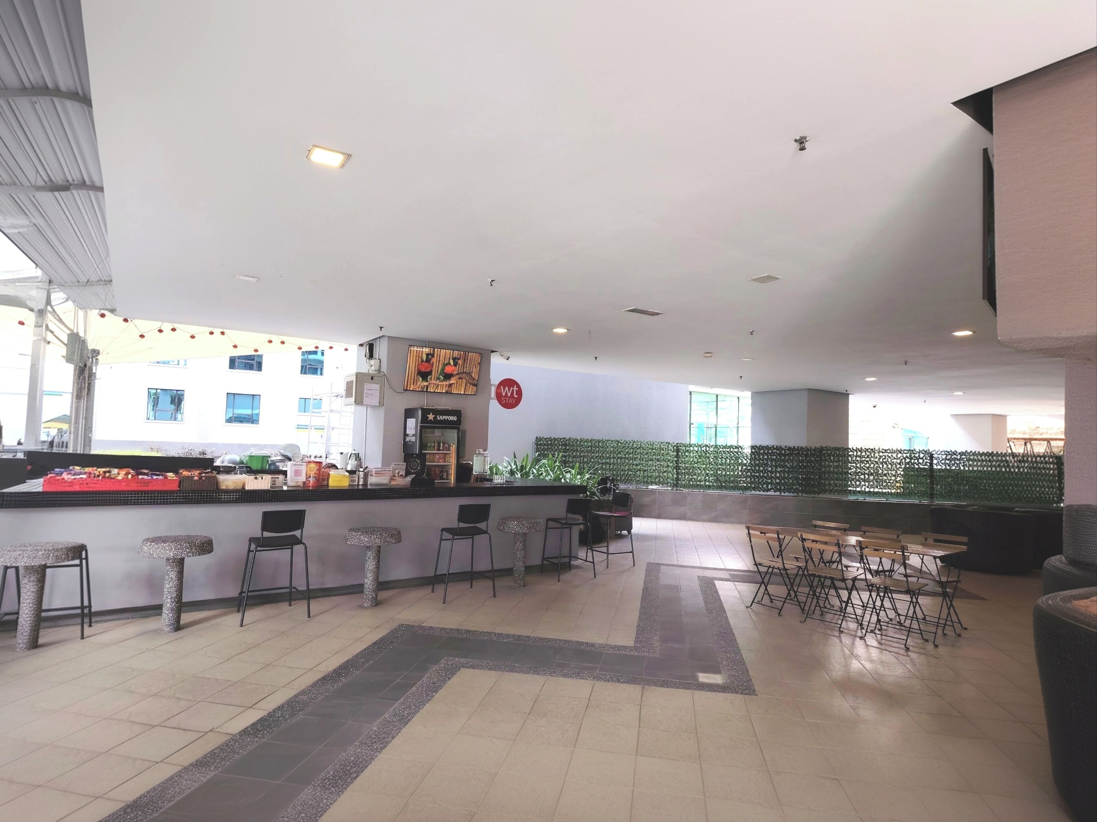 A spacious indoor area with a bar, seating, and a counter with various items.