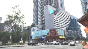 Un immeuble moderne de grande hauteur, doté de nombreux étages, qui se distingue par un logo bien visible et une signalétique indiquant qu’il s’agit d’un hôtel.