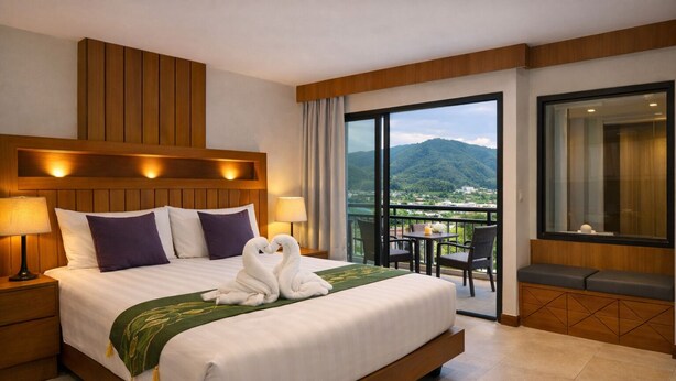 Habitación de hotel con una cama grande, dos lámparas, un balcón con mesa y sillas, y vistas a la montaña.