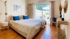 A bedroom with a large bed, a desk, a chair, a small table, and a window with curtains. - 6B Fabrica Velha Amazing Apartment Close TO THE (Lagoa)