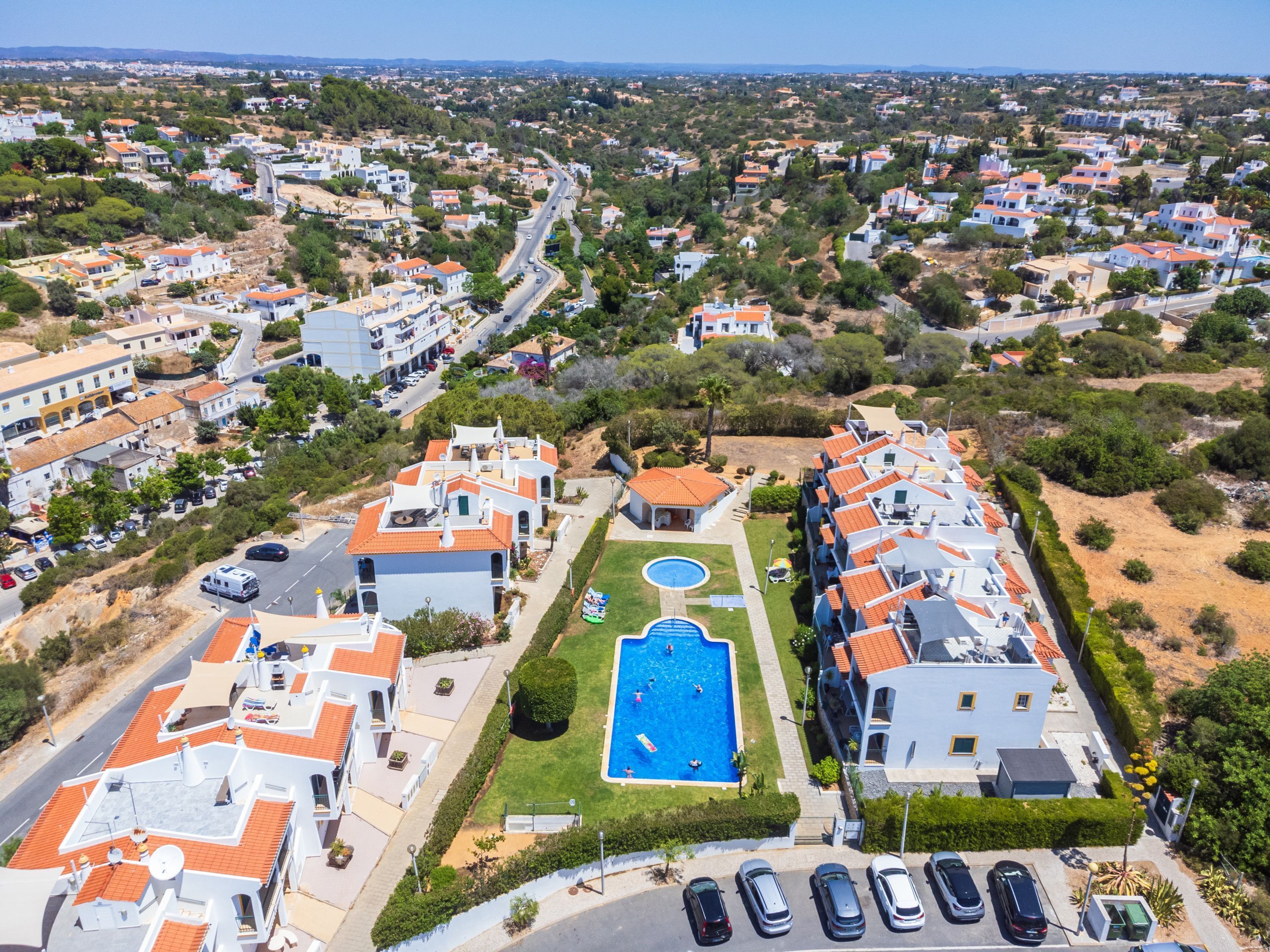 Un quartier résidentiel avec des maisons modernes, une piscine et une route.