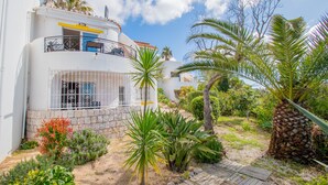 A two-story building with a balcony, surrounded by tropical plants and a wooden deck. - 115 Vale do Milho - Vista do Mar (Lagoa)