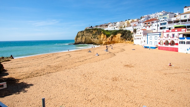 A beach with a cliff and buildings in the background. - Casa Flor do Mar in Carvoeiro (Lagoa)