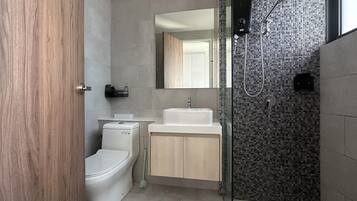 Un baño moderno con inodoro, lavamanos y ducha.