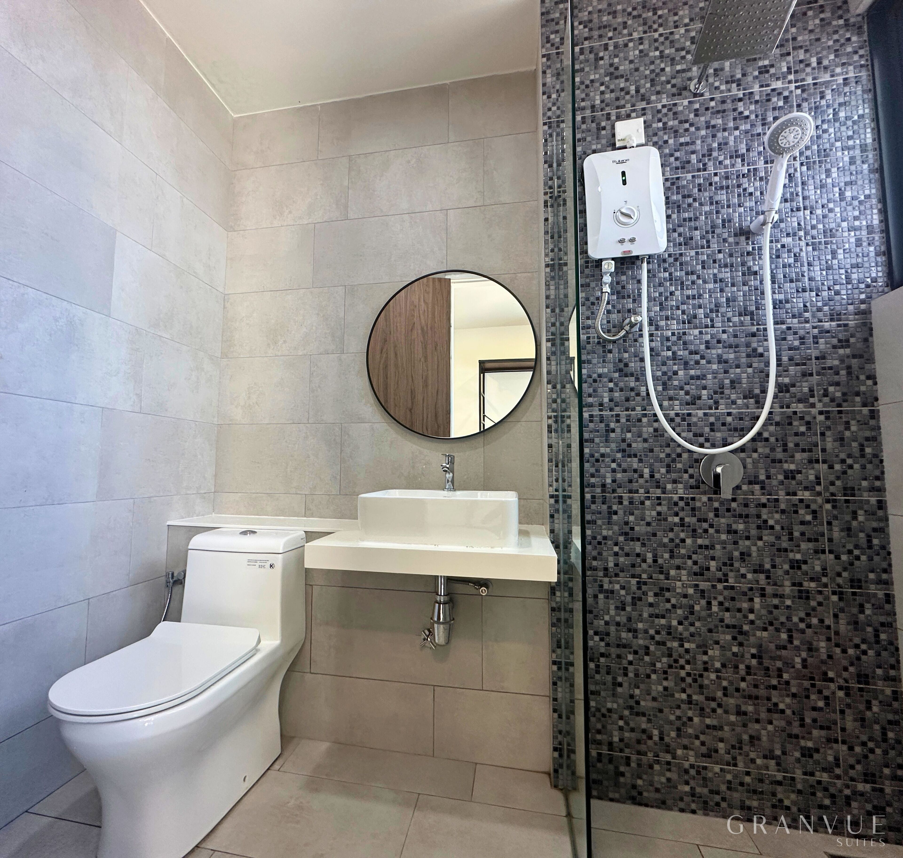 Ein Badezimmer mit Toilette, Waschbecken und Dusche mit Fliesen.