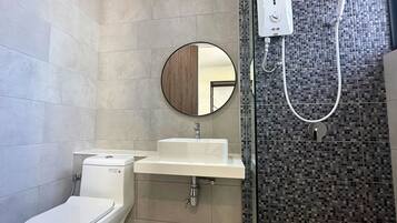 Ein Badezimmer mit Toilette, Waschbecken und Dusche mit Fliesen.