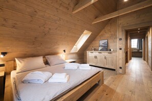 A wooden-paneled bedroom with a bed, nightstands, a built-in wardrobe, and a skylight. - Vysok nad Jizerou Lvta052 (Vysoké nad Jizerou)