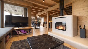 A modern living room with a fireplace, wooden beams, a television, and a dining area. - Vysok nad Jizerou Lvtu051 (Vysoké nad Jizerou)