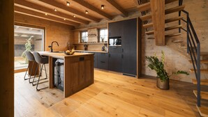 A modern kitchen with wooden beams, a central island, and a staircase. - Vysok nad Jizerou Lvtu051 (Vysoké nad Jizerou)