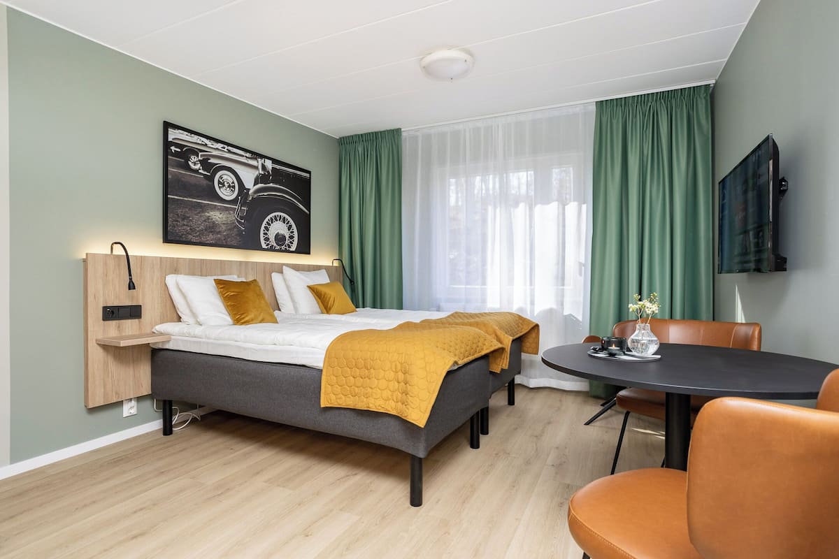 Une chambre d’hôtel moderne équipée d’un lit, d’un bureau et d’une télévision.