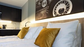 A hotel room with a bed, white bedding, a headboard, and a wall-mounted artwork. - Motellet Karlskrona (Karlskrona)