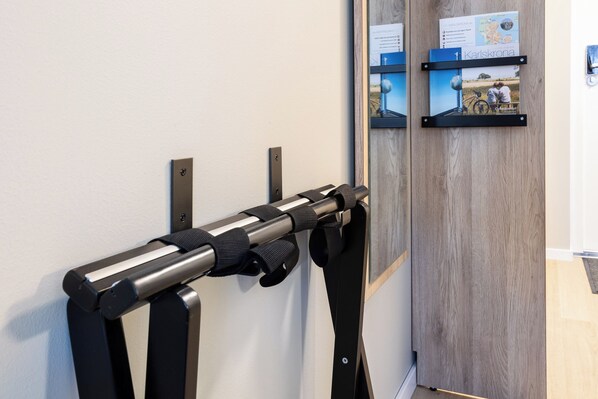 Un présentoir mural doté de sangles noires, d’une porte en bois et d’affiches d’information.