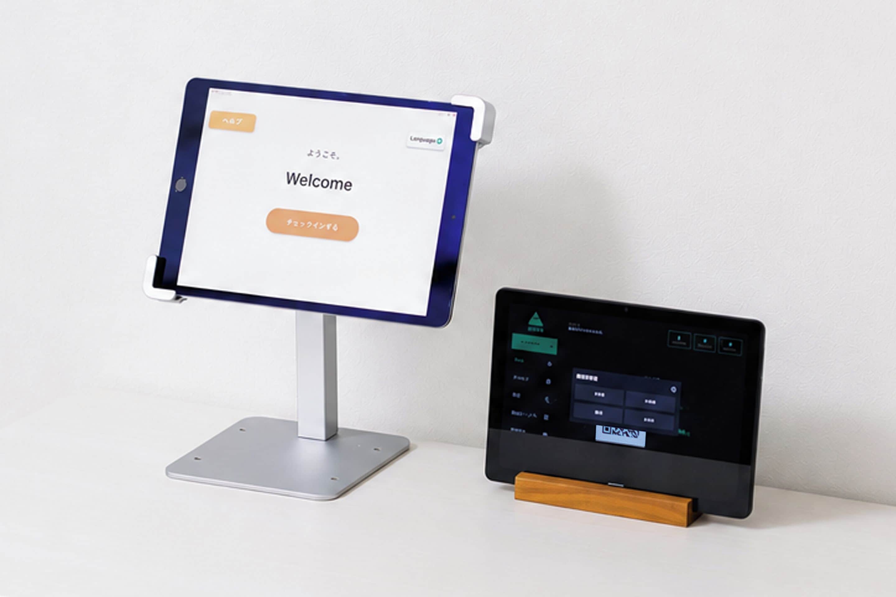 Een digitale kiosk met een welkomstscherm en een tablet waarop een menu wordt getoond.